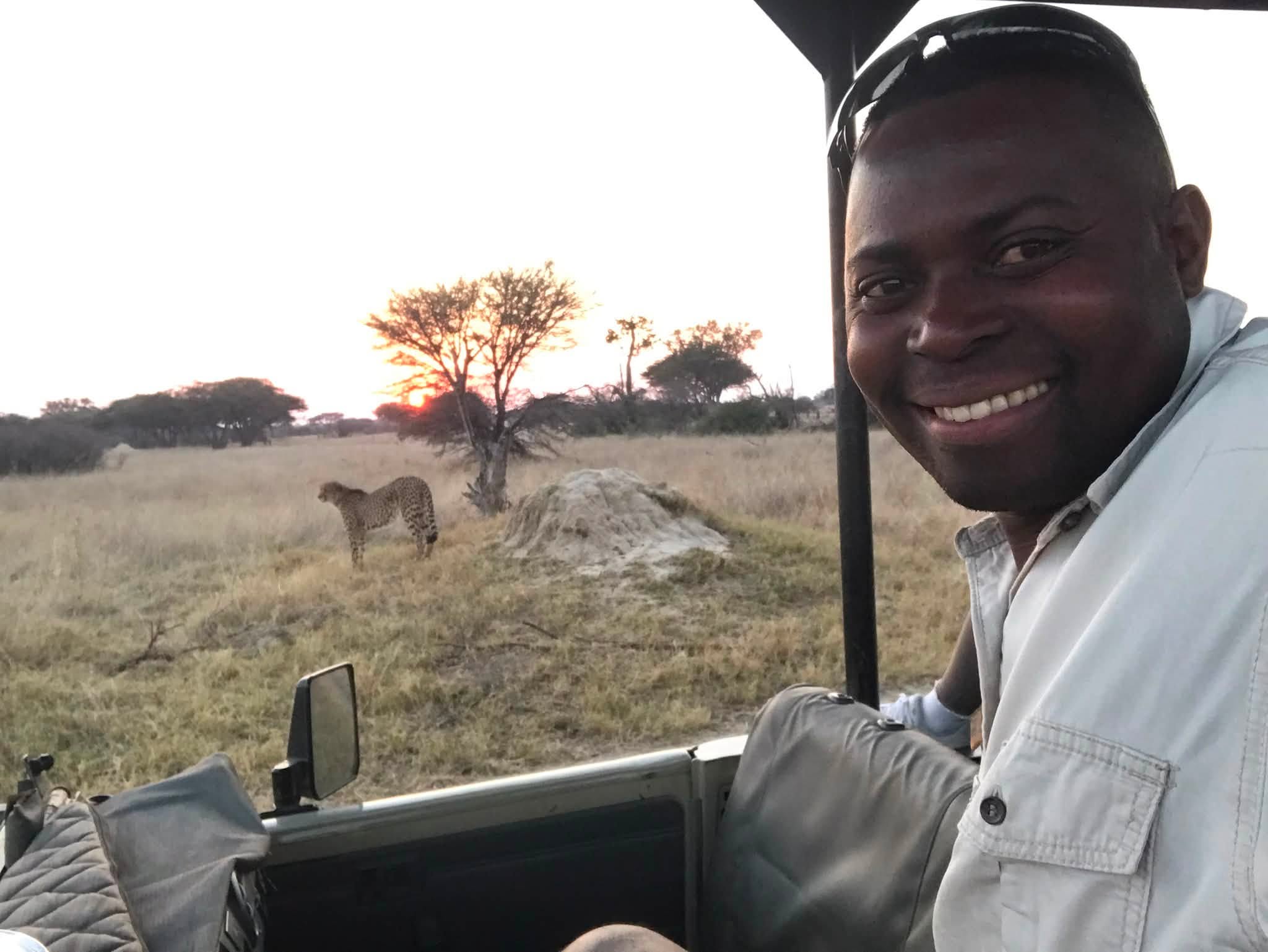 Toppers Muleya, safari guide at The Hide Safari Camp, with a cheetah at sunset in Hwange National Park, Zimbabwe